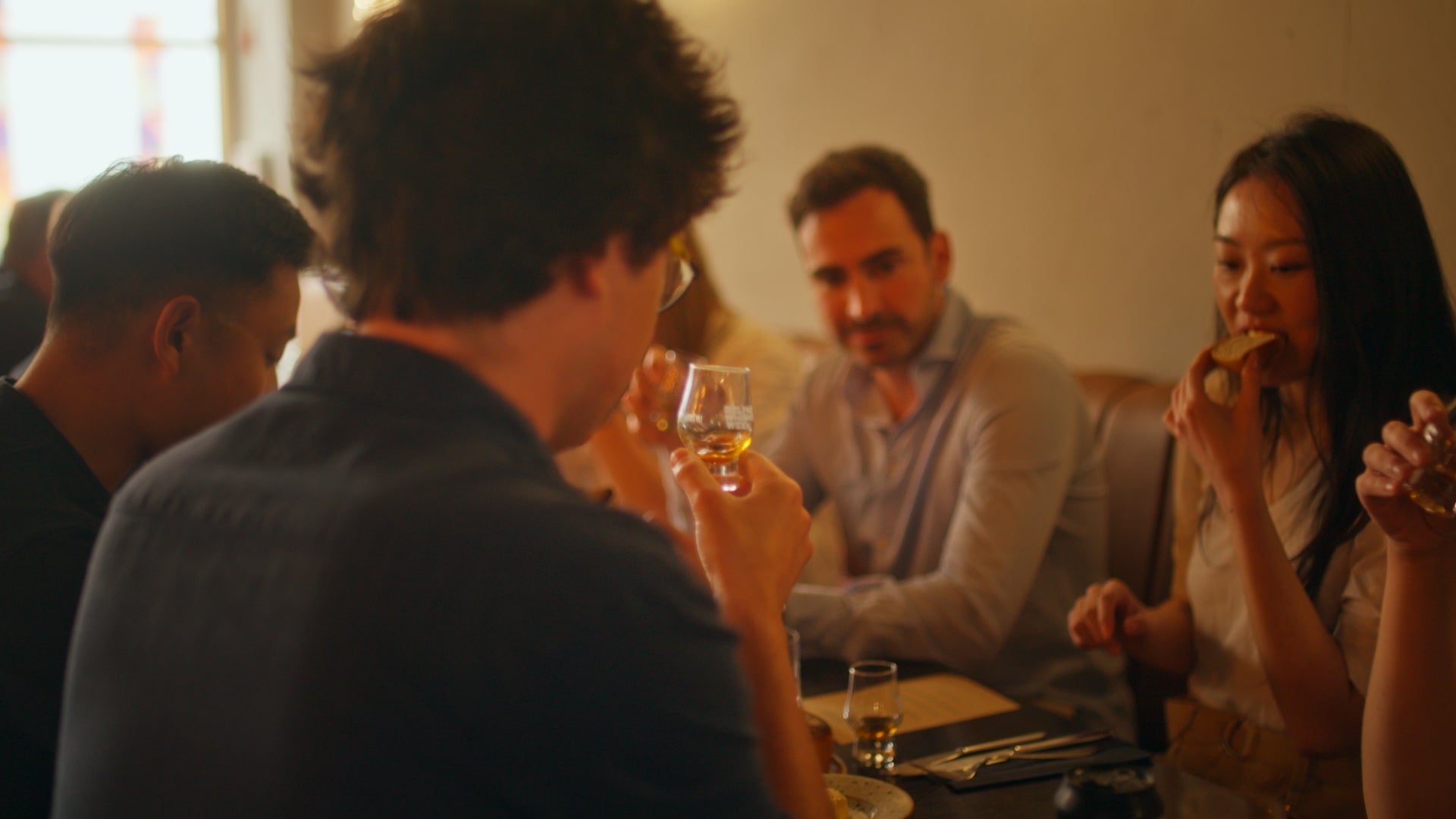 Guests enjoying a whiskey and food pairing event at Belfast Whiskey Week 2025, sipping from Glencairn tasting glasses
