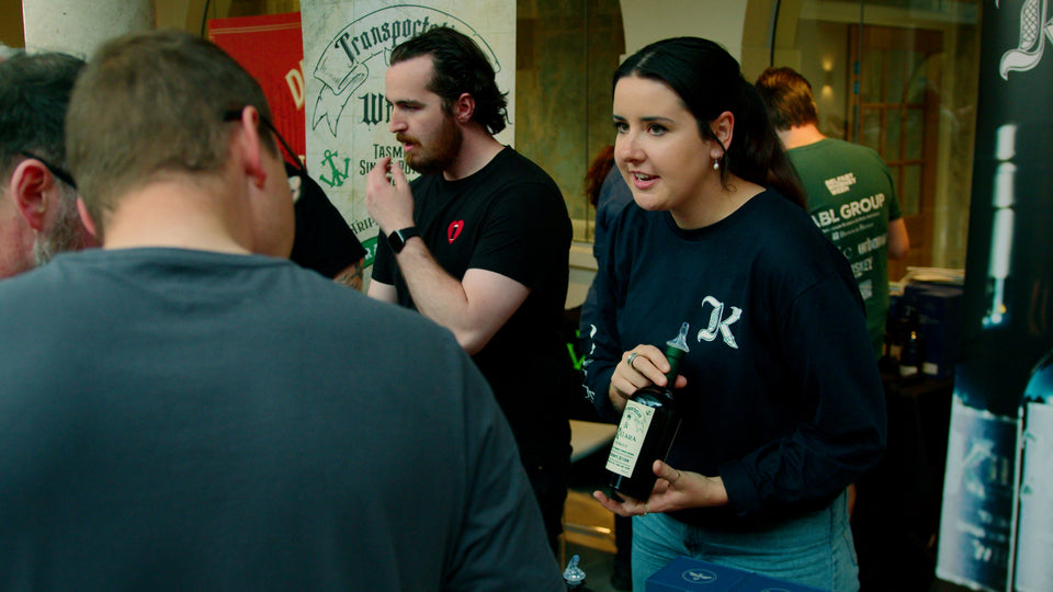 Kilara Irish whiskey brand ambassador presenting a bottle to visitors at Belfast Whiskey Week