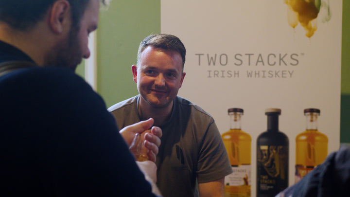 Two Stacks Irish Whiskey brand ambassador presenting the range to a visitor at Belfast Whiskey Week