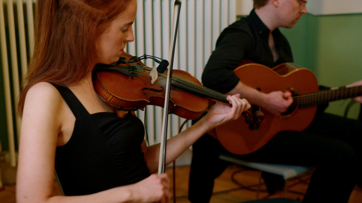 Live traditional Irish music duo performing fiddle and guitar at a Belfast Whiskey Week festival event