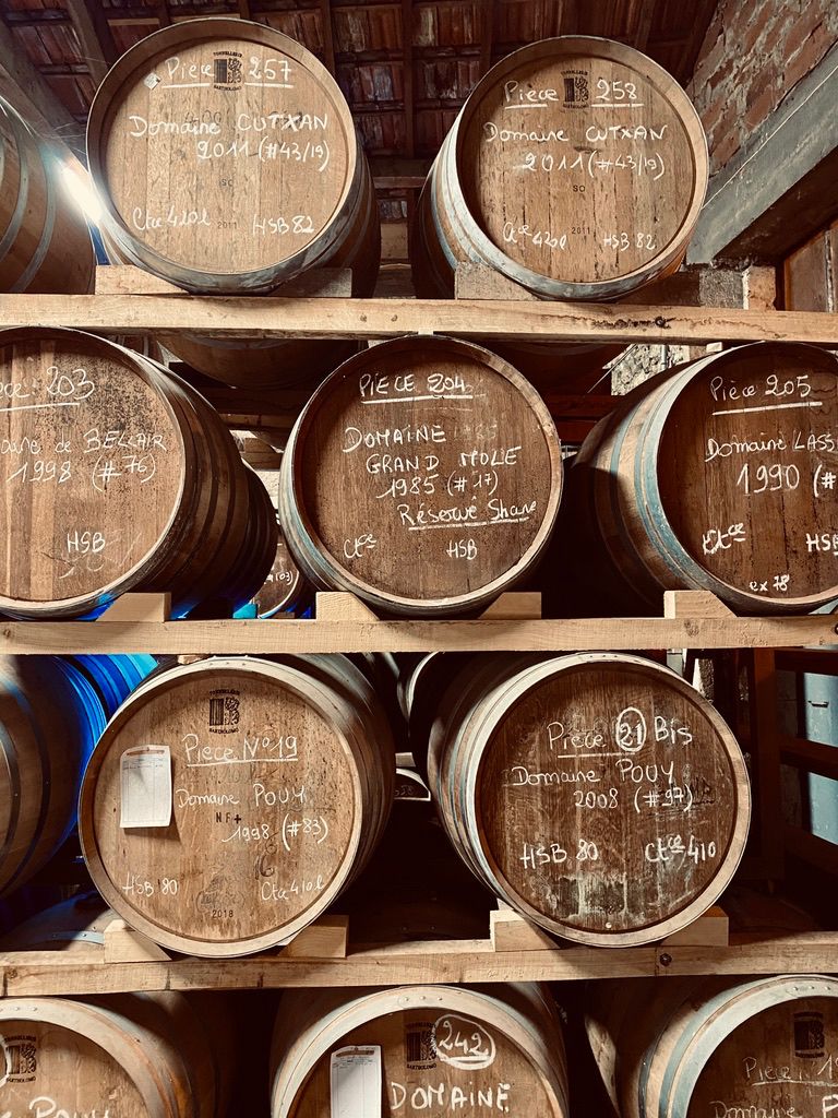 Stacked ageing casks in a cellar at an Armagnac distillery event