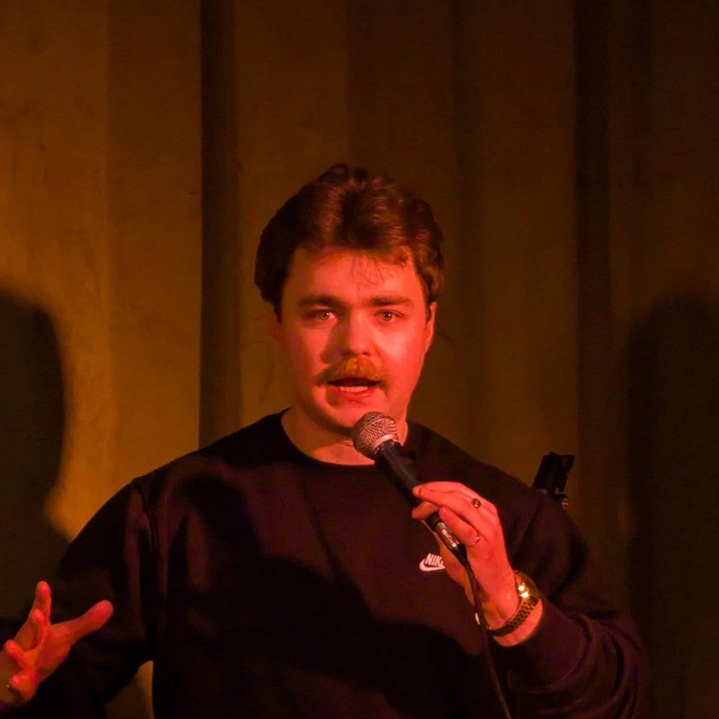 Live host speaking into a microphone at a Belfast Whiskey Week event