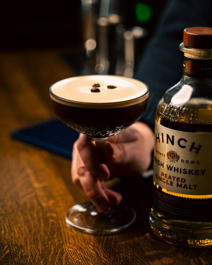 Espresso martini alongside a bottle of Hinch Peated Single Malt Irish whiskey
