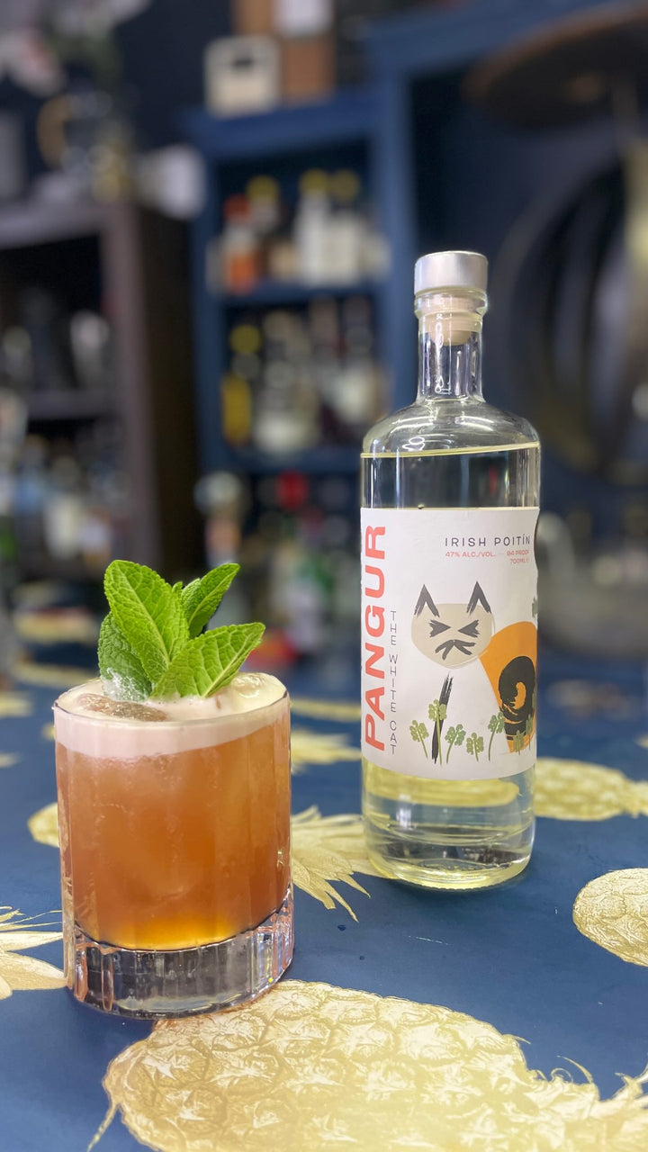 Cocktail made with Killowen Pangur Irish poitín beside the bottle