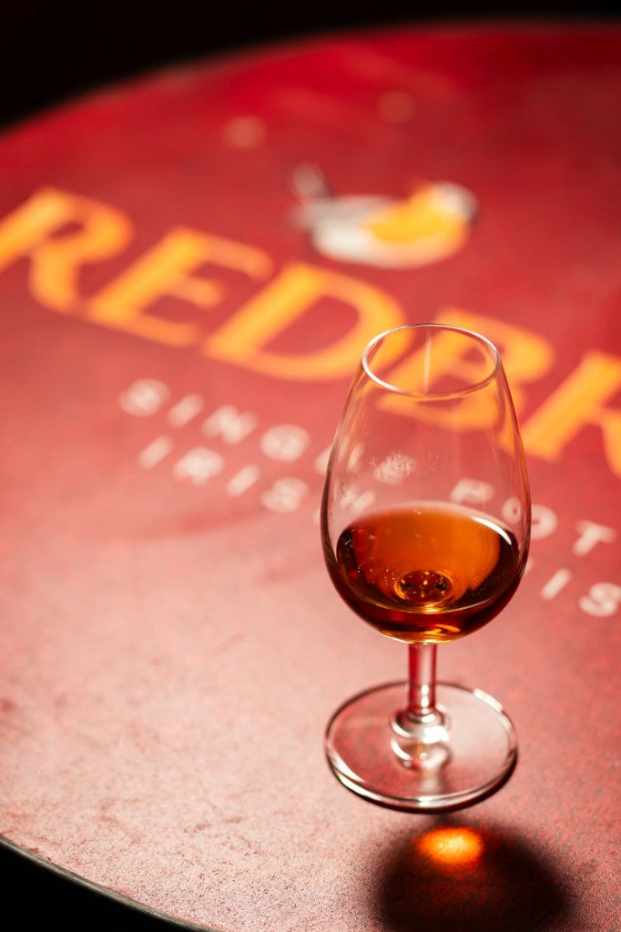 Redbreast single pot still Irish whiskey tasting glass on a branded Redbreast table at Quite the Find